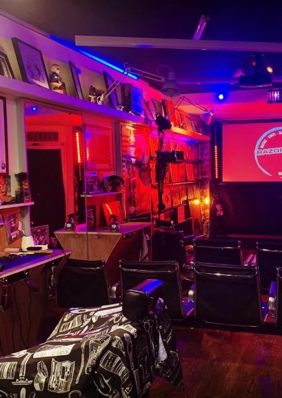 Neon-lit barbershop interior with framed prints